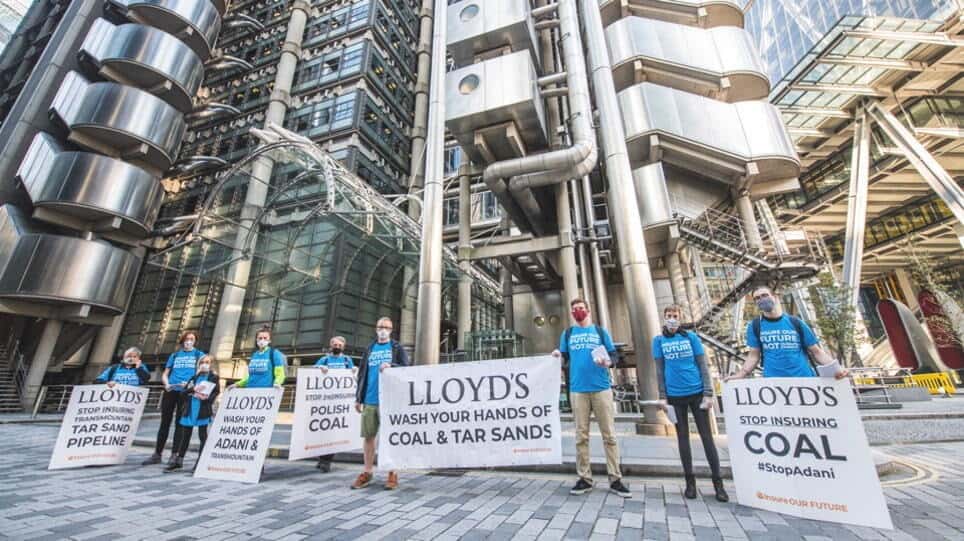 Activists stand in front of Lloyds Bank London with signs demanding an end to their involvement in coal and tar activities